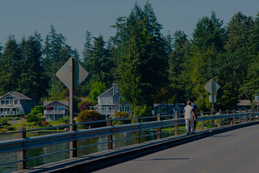 People walking near the American Lake residential area in Lakewood, highlighting a community served by Diligence Security Patrol Services and On-site Security Officers.