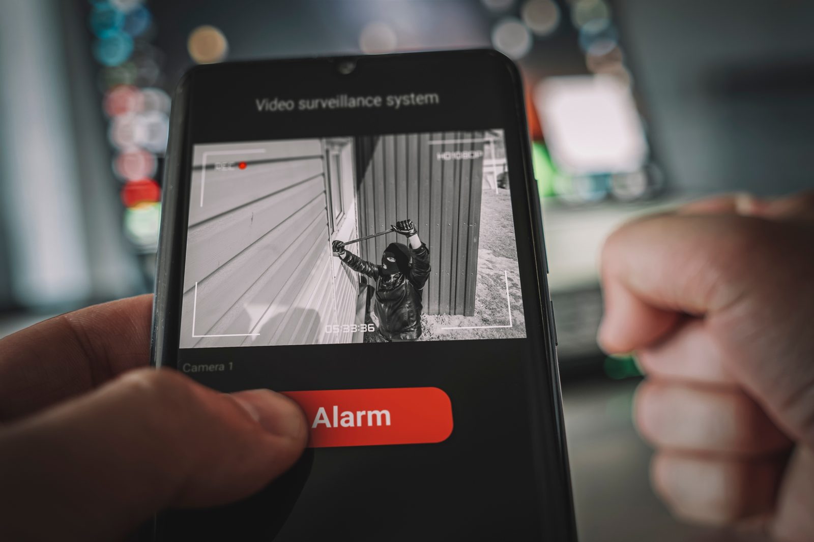 A property owner witnessing a break-in via surveillance, highlighting the need for unarmed private security to provide immediate onsite response
