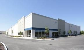 A wide-angle view of a large commercial warehouse and distribution facility in the Fife industrial corridor served by Diligence Security Officers.