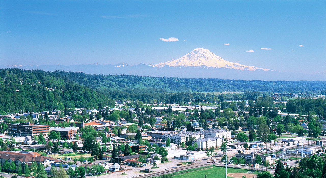 An aerial view of Kent with Mount Rainier in the background, highlighting a region served by Diligence Security Patrol Services and On-site Security Officers.