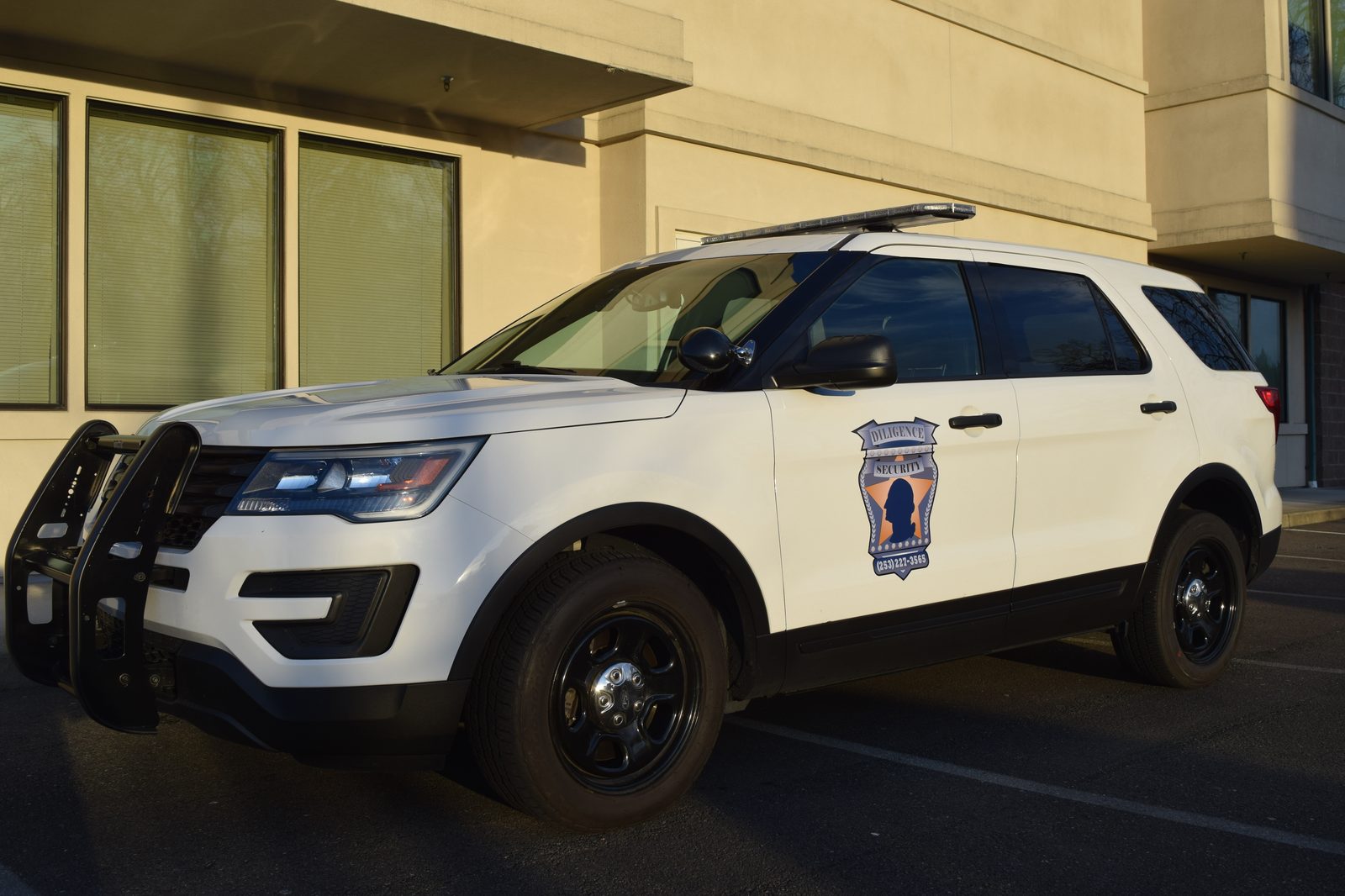 A marked Diligence Security patrol vehicle at a commercial property in Puyallup, demonstrating how Mobile Patrols deter crime for local small businesses
