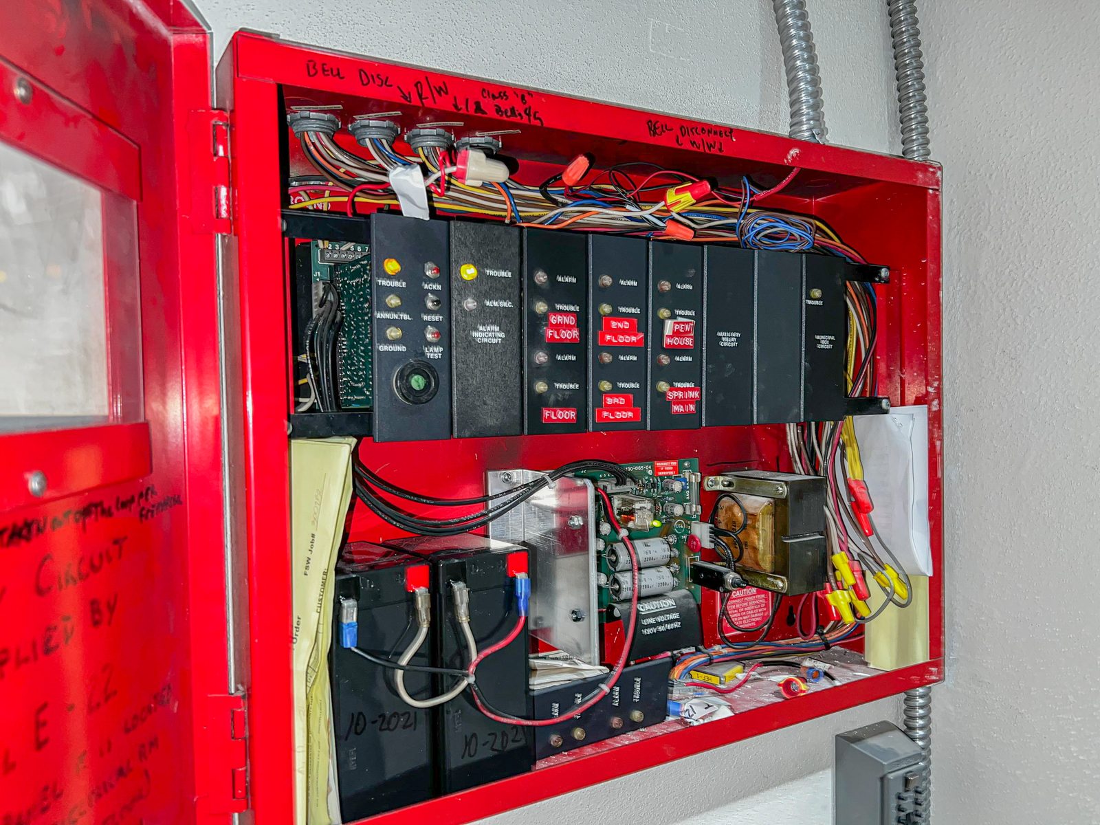 A Diligence Security Officer inspecting a commercial fire control panel during a Fire Watch assignment to maintain code compliance.